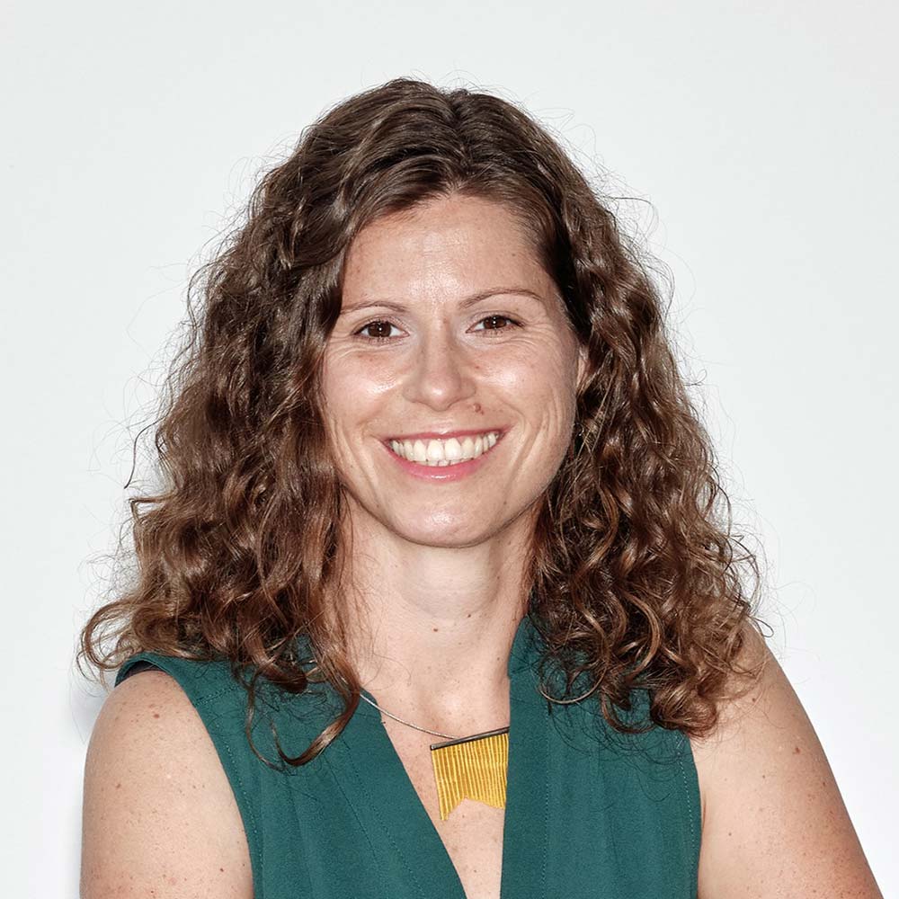 Alma Spribille, Geschäftsführerin WEtell GmbH, Vorständin Bundesverband Nachhaltige Wirtschaft e.V.: Junge Frau mit schulterlangen, lockigen, braunen Haaren lacht in die Kamera.