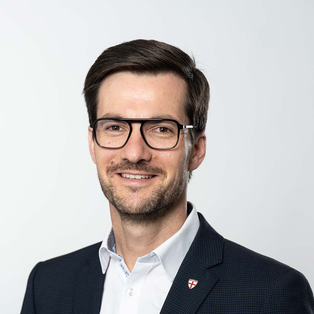 Martin Horn, Oberbürgermeister Freiburg im Breisgau: Junger Mann mit dunklen Haaren, schwarzer Brille und in blauen Anzug.